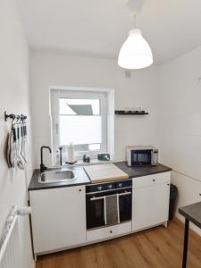 a small kitchen with a sink and a microwave at MILPAU Buer in Gelsenkirchen