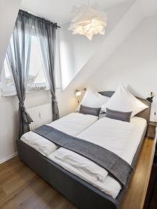 a bedroom with a bed with white sheets and a window at MILPAU Buer in Gelsenkirchen
