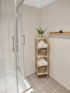 a bathroom with a shower and a shelf with towels at MILPAU Buer in Gelsenkirchen