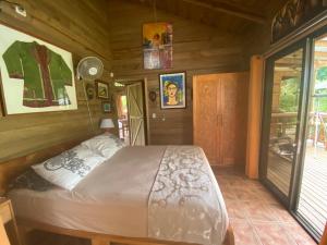 a bedroom with a bed in a wooden room at Casa Mediterránea with Pool and 2500 m2 Garden near Beach and Rain Forest in Uvita