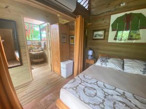 a bedroom with a bed in a wooden house at Casa Mediterránea with Pool and 2500 m2 Garden near Beach and Rain Forest in Uvita