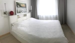 a white bed in a bedroom with a window at Home sweet home in Radviliškis