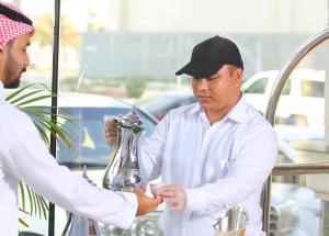 a man is handing another man a glass vase at Royal Golden House in Dammam +37 photos