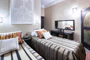 Habitación de hotel con cama y espejo en Hotel Azoul en Ouarzazate