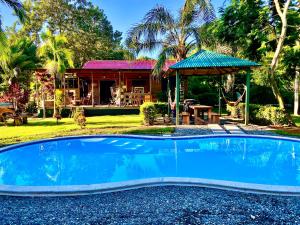a swimming pool in front of a house at Casa Mediterranea Uvita Oasis with Villa Cabins and Apartment in Uvita