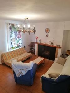 sala de estar con 2 sofás y chimenea en TIO TESORO, en Los Romeros