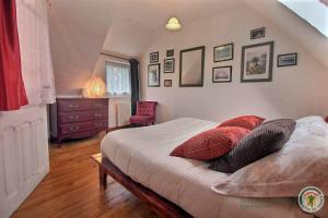 Un dormitorio con una cama con almohadas rojas. en Gîtes Air Marin, en Becléguer