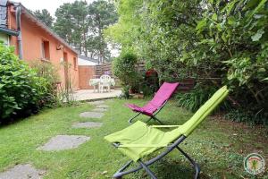 two lawn chairs sitting in the grass in a yard at Gîtes Air Marin in Becléguer