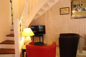 a living room with two red chairs and a television at Gîtes Air Marin in Becléguer