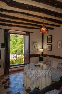 a living room with a table and a large window at Casa-Huerto La Juana in Trevélez