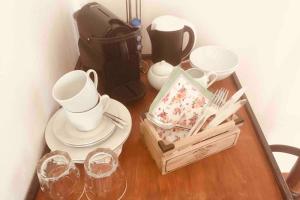 a wooden table with dishes and glasses and a bag at Hof Rabenstein Ostsee bei Kühlungsborn in Kröpelin