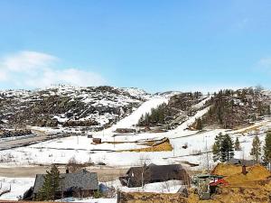 einen schneebedeckten Hügel mit Häusern und einem Berg in der Unterkunft 6 person holiday home in ÅSERAL-By Traum in Åseral