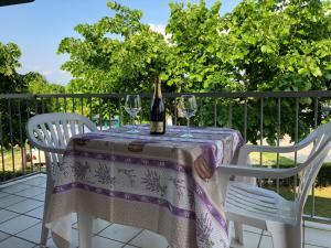 a bottle of wine sitting on a table with two chairs at Ohana Apartments Camping Tiglio in Sirmione