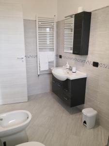 een witte badkamer met een wastafel en een toilet bij B&B Il Papavero Rosso in Corigliano dʼOtranto