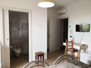 a room with a table and chairs and a bathroom at B&B Il Papavero Rosso in Corigliano dʼOtranto