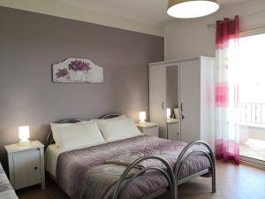 een slaapkamer met een bed met 2 stoelen en een raam bij B&B Il Papavero Rosso in Corigliano dʼOtranto