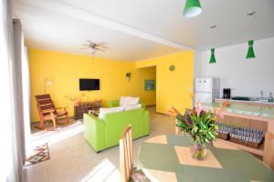 sala de estar con paredes amarillas y sofá verde en Supercostarica en Grecia