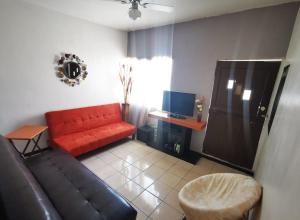sala de estar con sofá rojo y TV en departamento cd juarez, en Ciudad Juárez