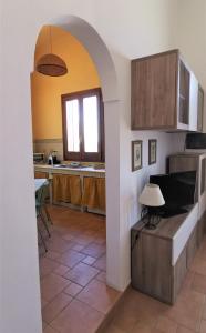 une cuisine avec une arche menant au salon dans l'établissement Birbiciù, à Pantelleria