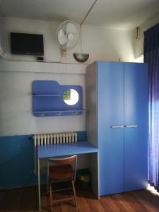 ローマにあるトゥー ダックス ホステルの青いデスクと椅子が備わる小さな客室です。