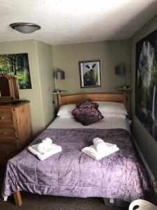 a bedroom with a bed with two towels on it at Anchor cottage in Brixham