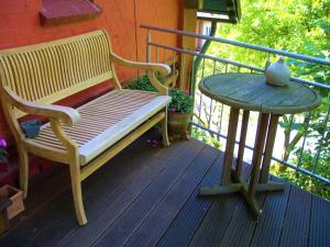 a wooden bench and a table on a porch at Ferienhaus Eichhof, Garlstorf - Lüneburger Heide in Garlstorf