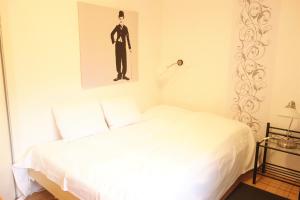 un dormitorio con una cama blanca y una foto de un hombre en FeWo Katharina (Teestube Undeloh) Lüneburger Heide, en Undeloh
