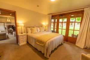 a bedroom with a bed and a large window at Wanaka Homestead Lodge & Cottages in Wanaka