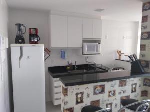 a kitchen with a sink and a microwave and a refrigerator at Lazer nas Alturas in Vila Velha