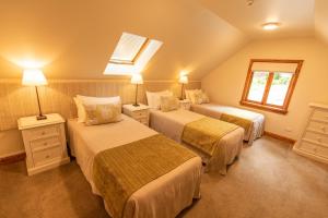 a hotel room with two beds and a window at Wanaka Homestead Lodge & Cottages in Wanaka