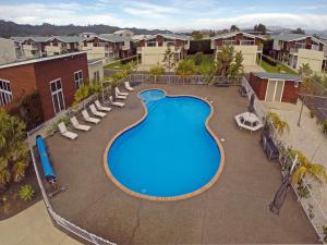 an overhead view of a swimming pool at a resort at Beachside Resort Motel Whitianga in Whitianga