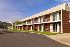 a large brick building with a large window at Beachside Resort Motel Whitianga in Whitianga