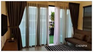 a living room with a couch and large sliding glass doors at Mary's Residence Ipoh in Ipoh