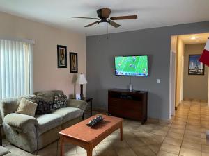 een woonkamer met een bank en een flatscreen-tv bij Casa Flores & Flores in Ensenada
