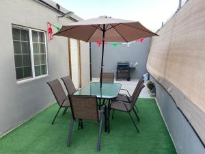 een tafel en stoelen met een parasol op een patio bij Casa Flores & Flores in Ensenada