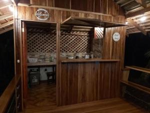 a kitchen with wooden cabinets and wooden floors at Bungalows Aché Cahuita in Cahuita