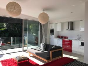 a living room with a couch and a kitchen at Sea La Vie - Waiheke Island Luxury Accommodation in Onetangi