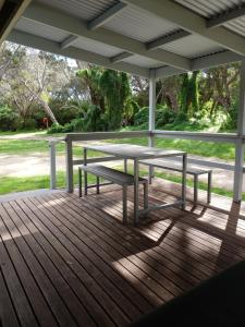a picnic table on a porch with a view of a park at Robe Holiday Park in Robe