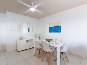 a white dining room with a white table and chairs at Kiah 8 stunning water views WI FI and Air Con in Nelson Bay