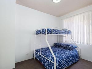 a bedroom with a bunk bed with blue sheets and a window at Kiah 8 stunning water views WI FI and Air Con in Nelson Bay