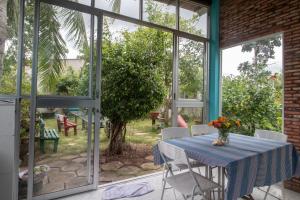 ein Esszimmer mit Tisch, Stühlen und Fenstern in der Unterkunft Vila Basi in Nguyệt Hạng