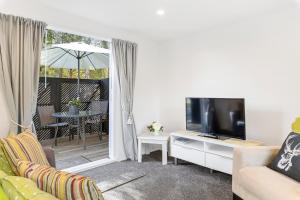 un salon avec un canapé et une télévision dans l'établissement Bellbird Cottage - Lake Taupo Bach, à Waitahanui 9 autres photos