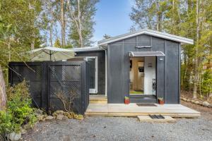 a black tiny house in the woods at Bellbird Cottage - Lake Taupo Bach in Waitahanui
