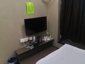 Cette chambre comprend un lit et une télévision à écran plat. dans l'établissement Tropika Garden Hotel, à Johor Bahru