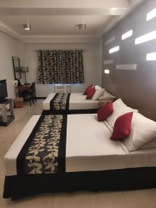 Jupiter Suites في مانيلا: سريرين في غرفة مع غرفة