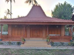 a wooden house with a porch and stairs at Buana Ecofarm Ecolodge in Grokgak