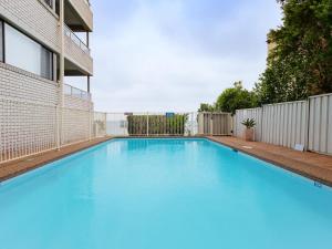 a large blue swimming pool next to a building at Bangalee 3 Fantastic Waterfront Unit with Pool WI FI and Chromecast in Soldiers Point