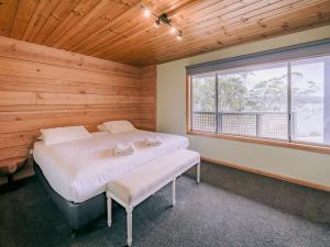 a bedroom with a large bed and a window at The Pier House in Lunawanna