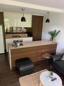 a living room with a couch and a kitchen at Centrepoint Units Heidelberg in Melbourne
