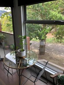 een glazen tafel en stoelen in een kamer met een raam bij Centrepoint Units Heidelberg in Melbourne